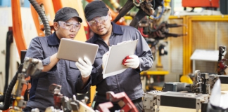 manufacturing workers with tablets for quality management system
